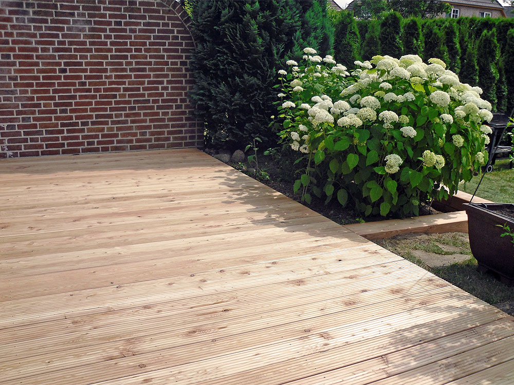 Nachher: Bangkirai-Anti-Slip als Terrasse, als Umrahmung für Hortensie wurden Gartenbauschwellen in "Sibirischer Lärche" gewählt